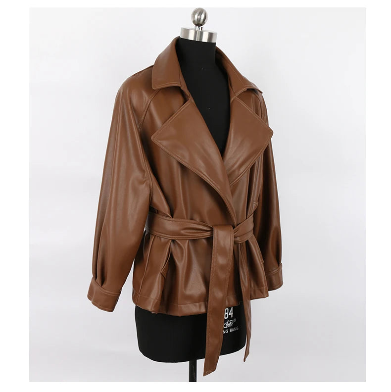 Mauroicardi 2025 Spring/Fall Collection – Women’s Short PU Leather Jacket. Crafted from soft, lightweight material with a fitted silhouette, raglan sleeves, and stylish sash detailing. Available in elegant brown and class
