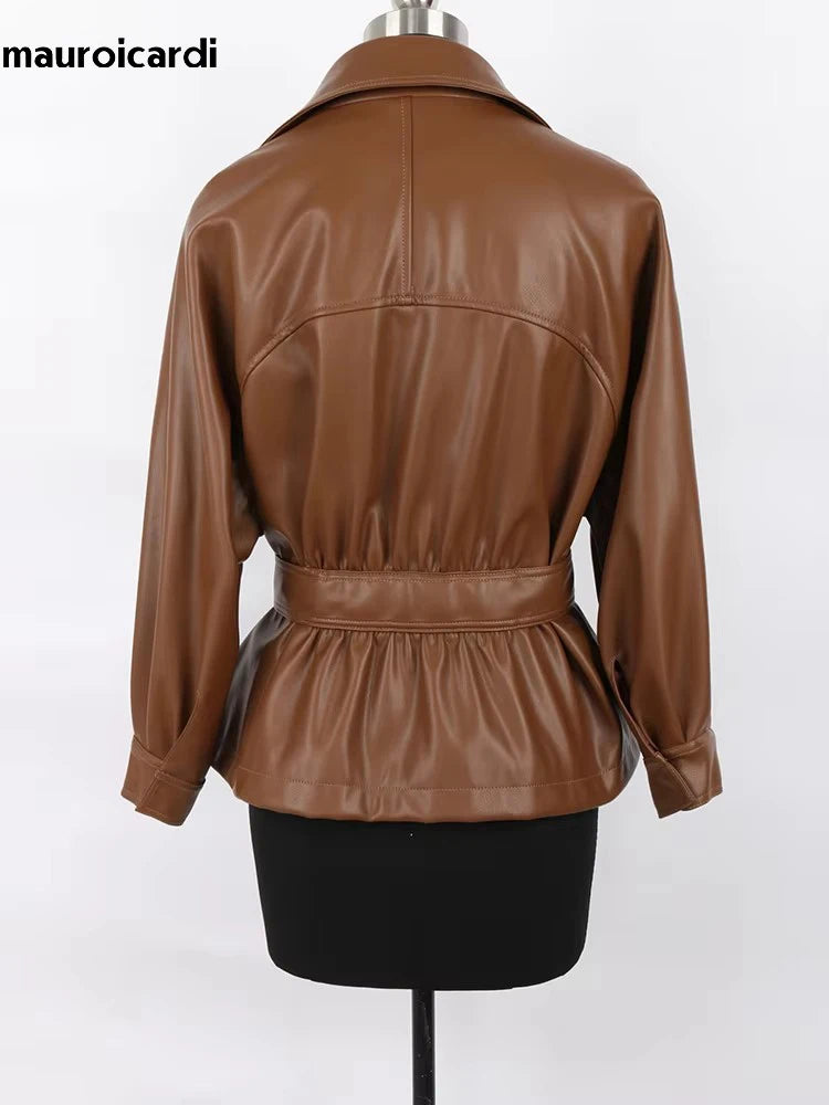Mauroicardi 2025 Spring/Fall Collection – Women’s Short PU Leather Jacket. Crafted from soft, lightweight material with a fitted silhouette, raglan sleeves, and stylish sash detailing. Available in elegant brown and class