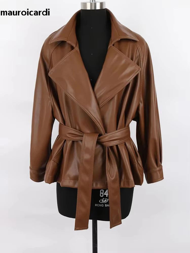 Mauroicardi 2025 Spring/Fall Collection – Women’s Short PU Leather Jacket. Crafted from soft, lightweight material with a fitted silhouette, raglan sleeves, and stylish sash detailing. Available in elegant brown and class