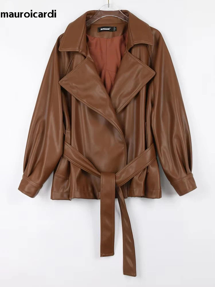 Mauroicardi 2025 Spring/Fall Collection – Women’s Short PU Leather Jacket. Crafted from soft, lightweight material with a fitted silhouette, raglan sleeves, and stylish sash detailing. Available in elegant brown and class
